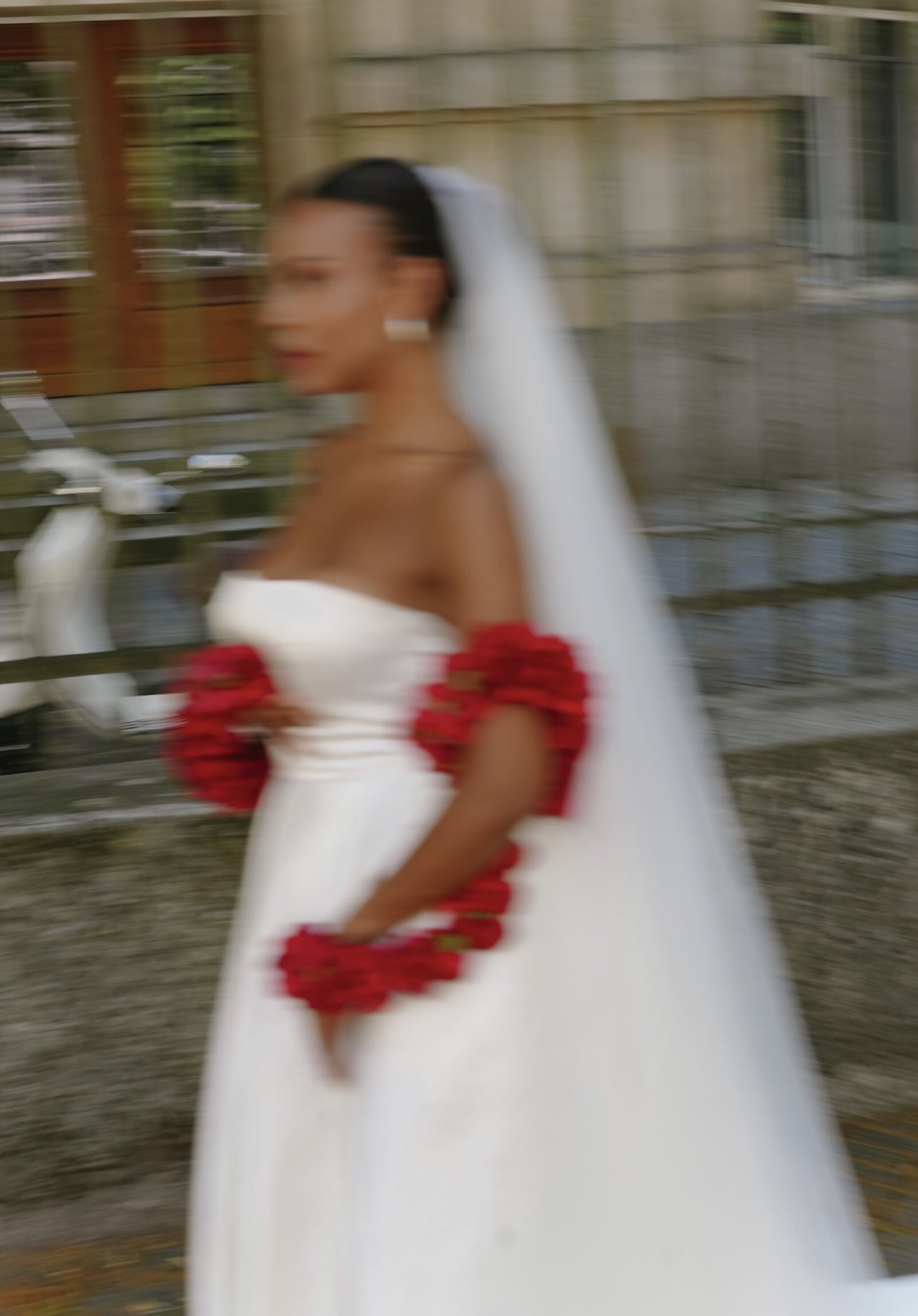 Bride in motion with garlands of red roses